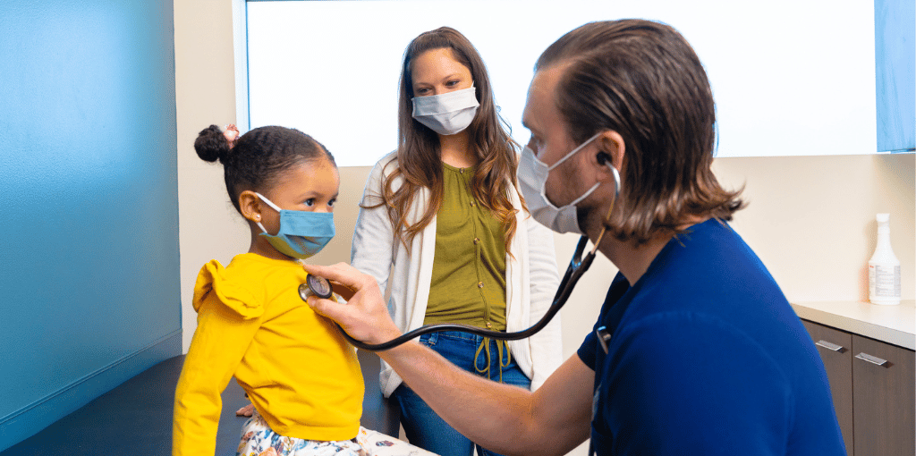  Little girl with her mom visiting with a doctor