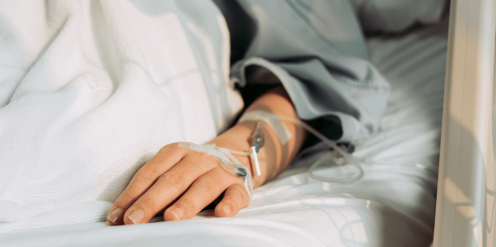 woman lying on bed with an IV in her left hand